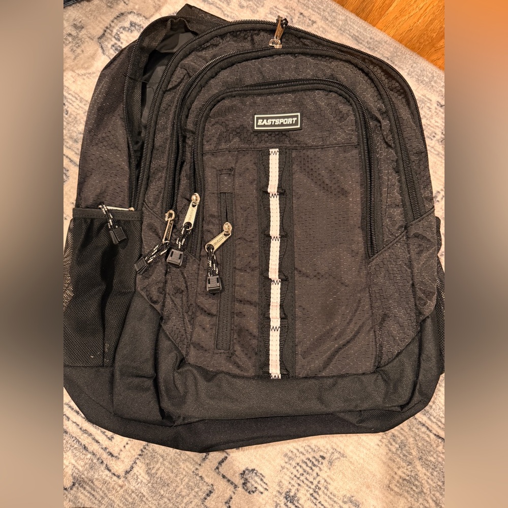 Black Eastsport backpack with white trim and water bottle pockets